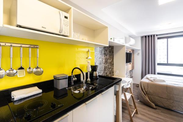 a kitchen with a sink and a yellow wall at Welcome CWB - AYN037 in Curitiba