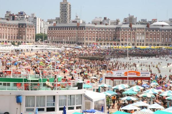 una gran multitud de personas en una playa con sombrillas en Depto. 3 AMBIENTES con balcón a la calle 2 cuadras de la playa en Mar del Plata