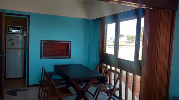 comedor con paredes azules, mesa y sillas en Departamento con Vista al Mar en Mar del Plata