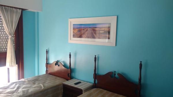 1 dormitorio azul con 1 cama y una foto en la pared en Departamento con Vista al Mar en Mar del Plata