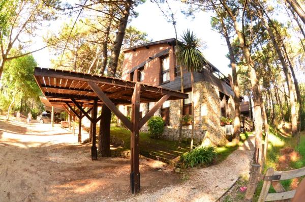 una casa con una estructura de madera delante de ella en Del Alumine en Mar de las Pampas