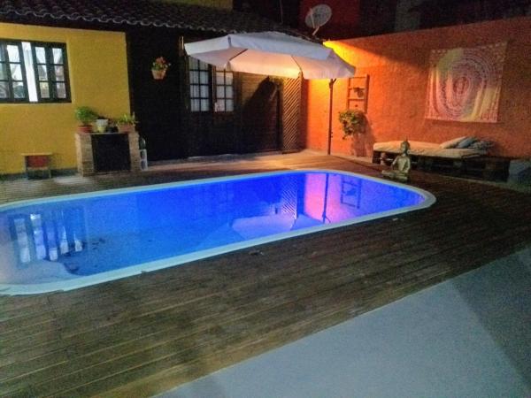 a swimming pool in a house with a blue poolvisor at Casa no Campeche com Piscina in Florianópolis