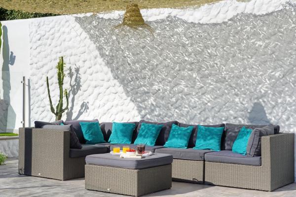 un sofá con almohadas azules frente a una pared en Villa Mamba By Seric,15' walking to the beach, en Torremolinos