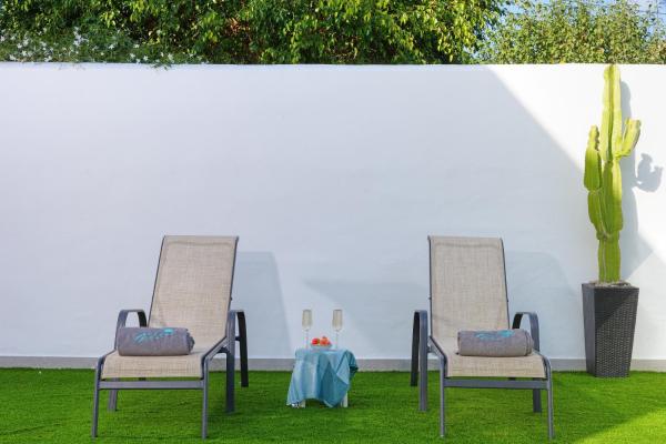 dos sillas y una mesa en la hierba con un cactus en Villa Mamba By Seric,15' walking to the beach, en Torremolinos
