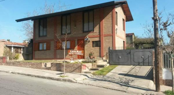 una casa de ladrillo con una puerta delante de ella en Cabañas de las Mellizas, en Villa Carlos Paz