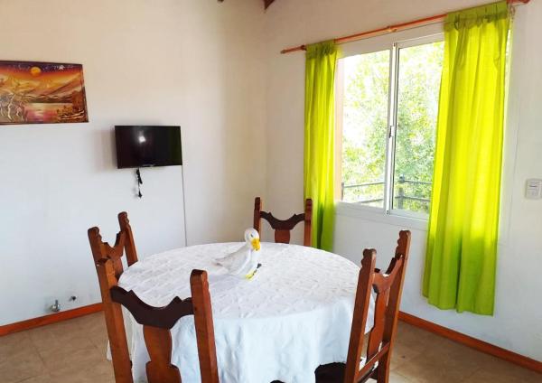 un comedor con una mesa blanca y una ventana en Sosiego, Gesell en Villa Gesell