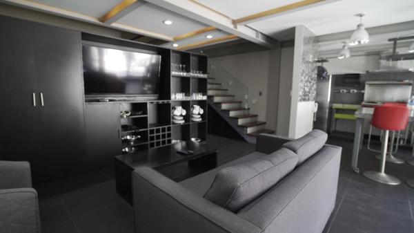 sala de estar con sofá y TV en 2 Bedroom Garden House Polanco, en Ciudad de México