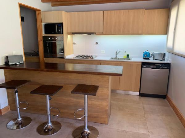 cocina con barra y 2 taburetes en Exclusivo departamento cerca del lago en San Martín de los Andes