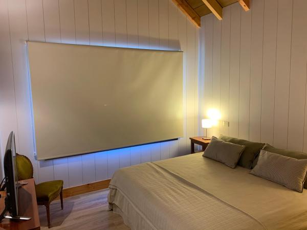 Una pantalla grande en una habitación con cama en Exclusivo departamento cerca del lago en San Martín de los Andes