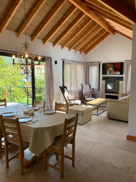 comedor y sala de estar con mesa y sillas en Exclusivo departamento cerca del lago en San Martín de los Andes