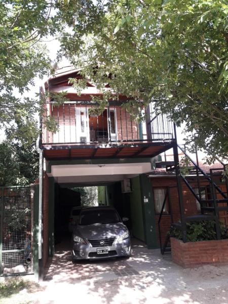 un coche aparcado bajo un edificio con balcón en Ariel Reynoso - Departamento Planta Alta, en Mina Clavero