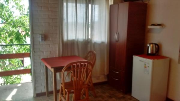 cocina pequeña con mesa pequeña y refrigerador en Hosteria Nido de Condores, en Mina Clavero