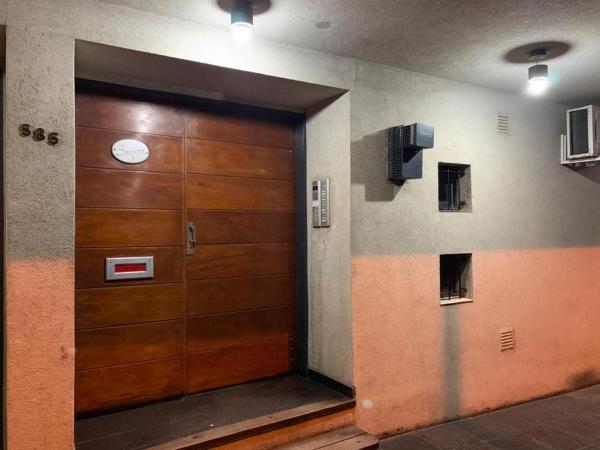 una puerta de madera en un pasillo con un reloj. en Serena en Villa Carlos Paz