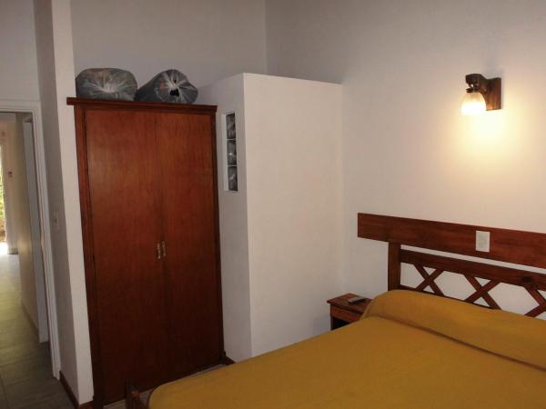 un dormitorio con cama y un armario de madera a 4 SOLES en Villa Gesell