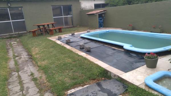 una piscina en un patio con una mesa y una mesa de picnic en La Casa Grande en Chascomús