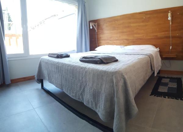 1 cama con 2 toallas en un dormitorio en UMAIN KAYU en San Martín de los Andes