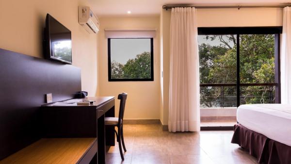 Habitación de hotel con cama, escritorio y ventana en Pirayu Hotel & Resort en Puerto Iguazú
