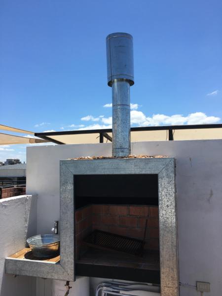 un horno al aire libre con una chimenea de ladrillo en el techo en Departamentos Premium Federación, en Federación