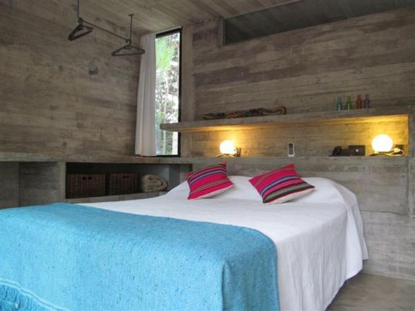 1 dormitorio con 1 cama blanca grande y 2 almohadas en V&D - Casas en Mar Azul en Balneario Mar Azul