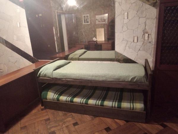 2 camas en una habitación con una pared de piedra en Convenientes departamentos equipados en Mar del Plata a metros del mar EDIFICIO ÚNICO cerca de todo en Mar del Plata