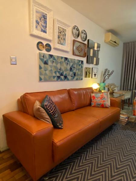 a brown leather couch in a living room at Apto continente Florianópolis in Florianópolis