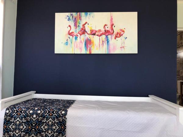 1 dormitorio con 1 cama con una pintura en la pared en Las Piedritas Casa de Mar en Las Grutas