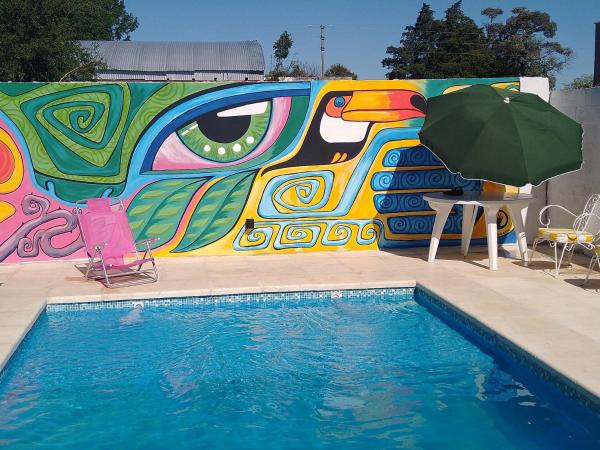 una piscina con una pared colorida y una sombrilla junto a ella en Casa En Gualeguaychu en Gualeguaychú