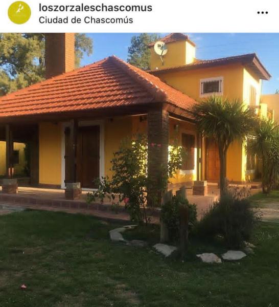 una pequeña casa amarilla con en Los zorzales quinta Chascomus en Chascomús