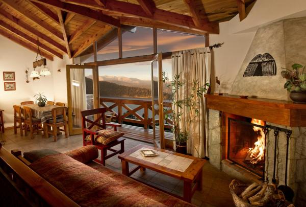 sala de estar con chimenea y mesa en Bungalows Buena Vista en San Carlos de Bariloche