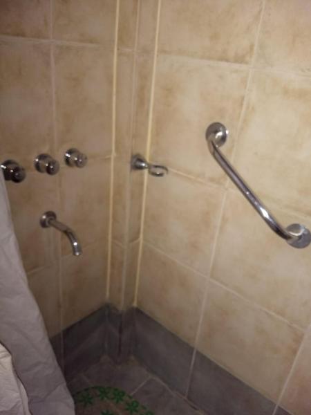 y baño con ducha y 2 barras de metal. en LAWIL Cabaña en Tandil