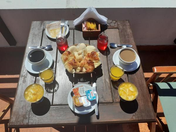 una mesa de madera con comidas y bebidas para el desayuno en la Hostería Santa Bárbara de Villa Gesell