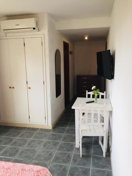 a room with a small white table and a television at San Remo Terrazas Hotel in Piriápolis