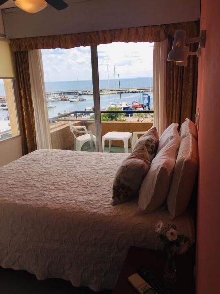 a bedroom with a large bed with a large window at San Remo Terrazas Hotel in Piriápolis