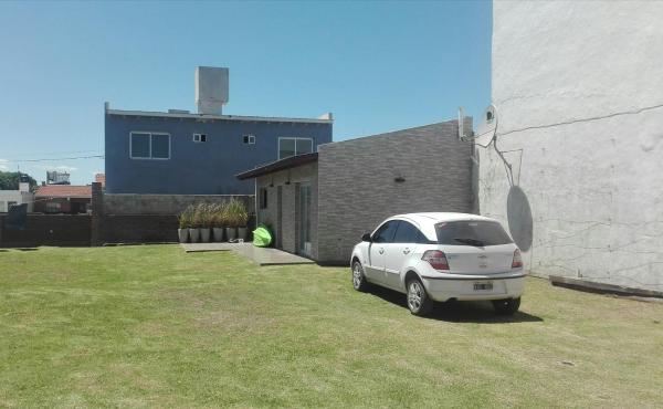 un coche blanco estacionado en un patio al lado de un edificio en Verdeymar en Santa Clara del Mar