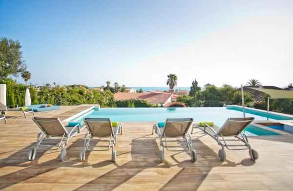 un grupo de sillas sentadas junto a una piscina en Extravagante 8 BDRM Villa In Marbella, Beachside, en Marbella