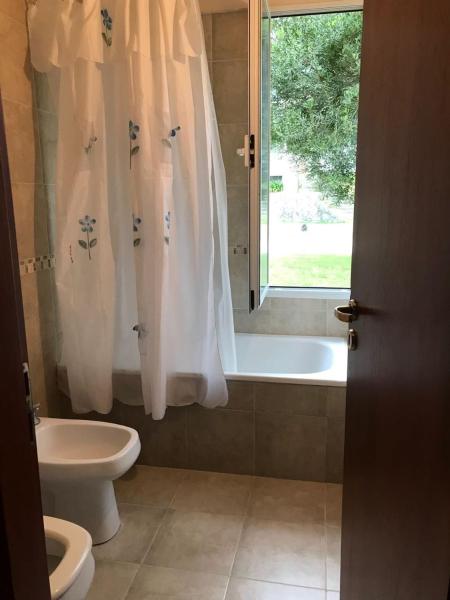 baño con bañera, aseo y ventana en Casa Juno Pinamar Norte en Pinamar