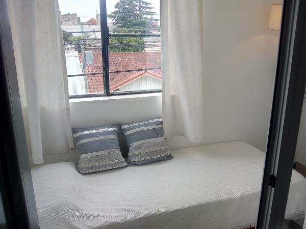 asiento junto a la ventana con 2 almohadas en una habitación en DTO SERRANO en Tandil