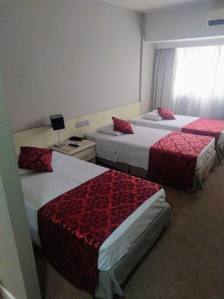 a hotel room with two beds and a window at Victoria Villa Curitiba in Curitiba