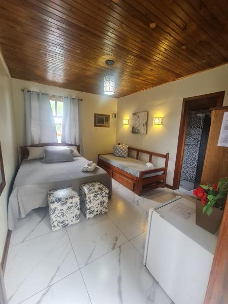 a large bedroom with two beds and a wooden ceiling at Hotel Praia Do Rosa in Praia do Rosa