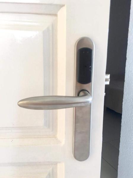 una manivela de puerta metálica sobre una puerta blanca en el Apart Amabile Sul Mare de Villa Gesell