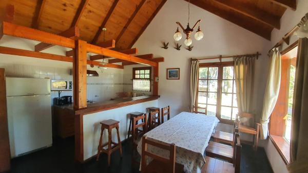cocina y comedor con mesa y sillas en Cabañas & Aparts Lancuyen, Villa de Montaña, en Villa La Angostura