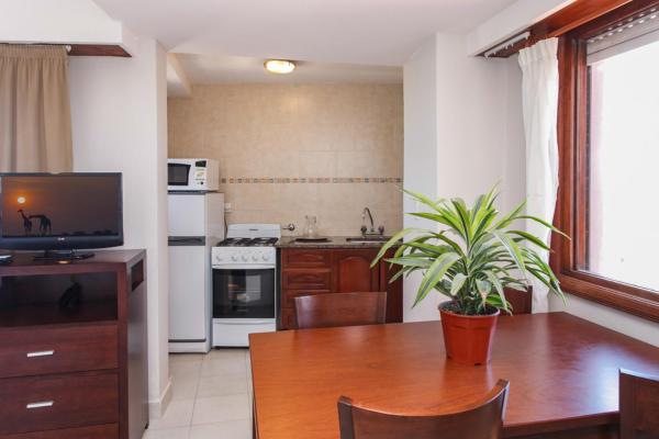una cocina con una mesa de madera con una planta en maceta en el Apart Hotel Torre Del Sol de Villa Gesell
