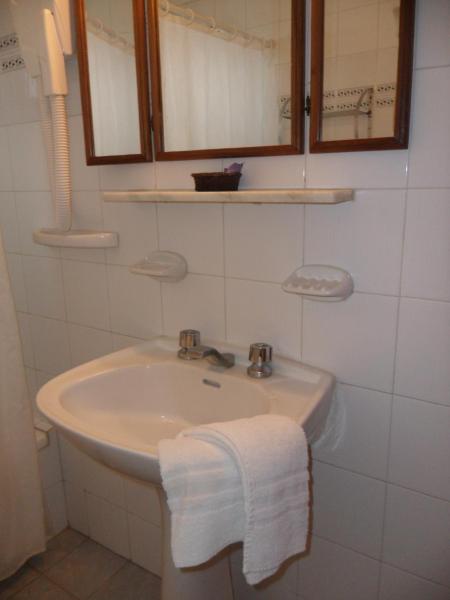 un baño con aseo y espejo en el Hotel de Música Montecarlo de Villa Gesell