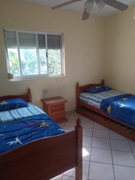 1 dormitorio con 2 camas, mesa y 2 ventanas en Departamento en Playa del Carmen, en Playa del Carmen