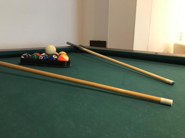 a pool table with billiard balls and sticks on it at Hotel Escorial in Piriápolis