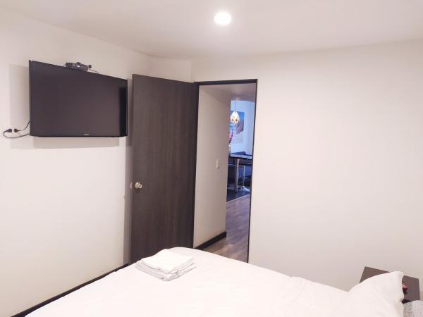 1 dormitorio con 1 cama y TV de pantalla plana en 7 Apartamento dos habitaciones Cedritos Minimalista, en Bogotá