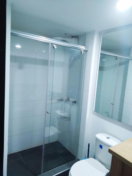 y baño con ducha de cristal y aseo. en 7 Apartamento dos habitaciones Cedritos Minimalista, en Bogotá