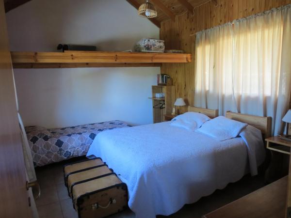 1 dormitorio con cama blanca y ventana en Cabaña Paseo del Sol en San Martín de los Andes