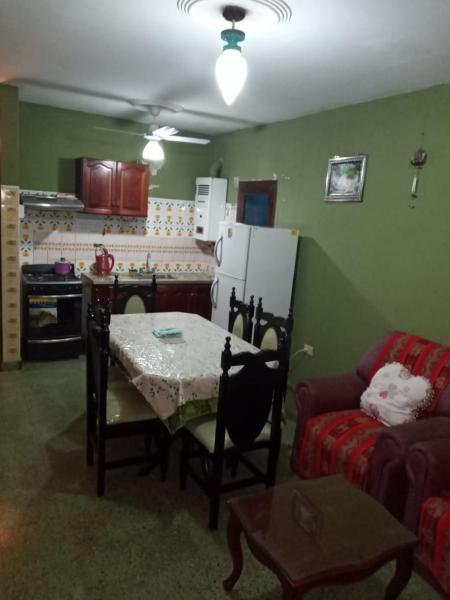 sala de estar con mesa, sofá y cocina en Departamentos Mis Viejos Queridos en Salta