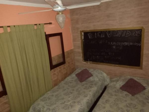 1 dormitorio con cama y pizarra en la pared en Departamentos Mis Viejos Queridos en Salta